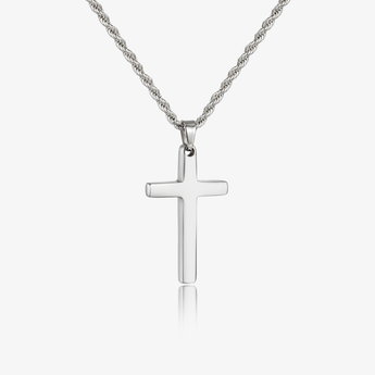 Collar tono plateado con dije de cruz y cadena trenzada sobre un fondo claro