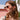 Mujer con gafas de sol usando un arete de aro trenzado en tono dorado al aire libre