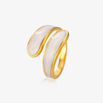 Anillo abierto envolvente en tono dorado con incrustación marmoleada blanca sobre fondo claro