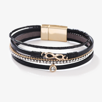 Pulsera negra multicapa de cuero PU con dije infinito dorado sobre fondo blanco