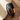 Pulsera negra multicapa con dije infinito y cadena de cristales sobre una superficie de madera
