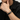 Close-up of a person wearing a black braided bracelet charging cable with an engraved clasp