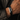 Man wearing a black braided leather bracelet with a silver-tone plate engraved DON'T LET THE HARD DAYS WIN