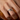 Primer plano de una mano con un anillo abierto envolvente plateado grabado con el texto Love U