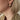 Primer plano de una oreja con un arete de aro triple acanalado en tono dorado